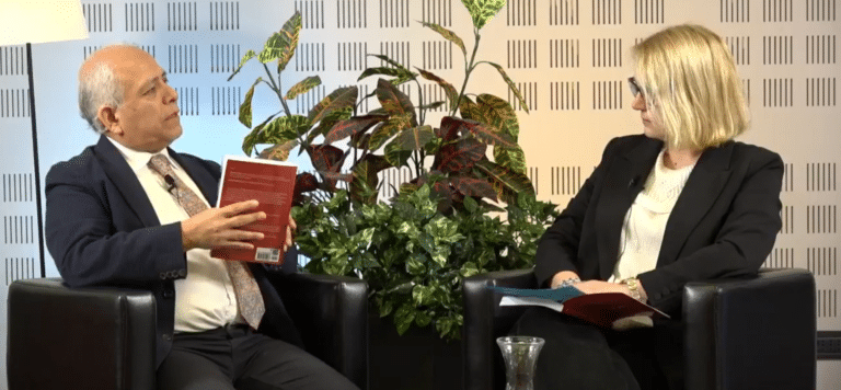 Un uomo e una donna conversano seduti durante la presentazione di un libro