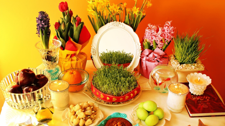 Tavola per il Nowruz con fiori, frutta, germogli e uno specchio