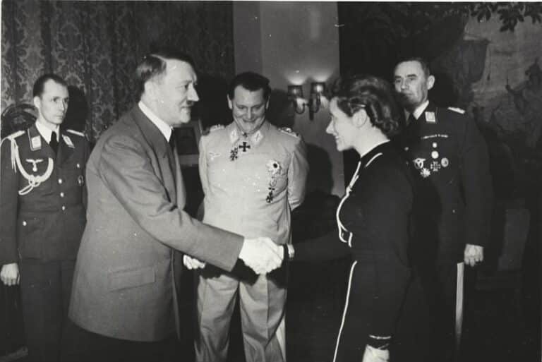 Fotografia storica della cerimonia in cui Adolf Hitler consegna una decorazione a Hanna Reitsch, con Hermann Göring al centro