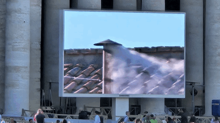 Uno schermo mostra la fumata bianca dal comignolo della Cappella Sistina