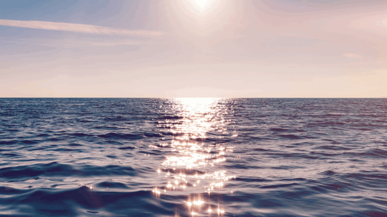 Il sole si riflette sul mare calmo all’orizzonte