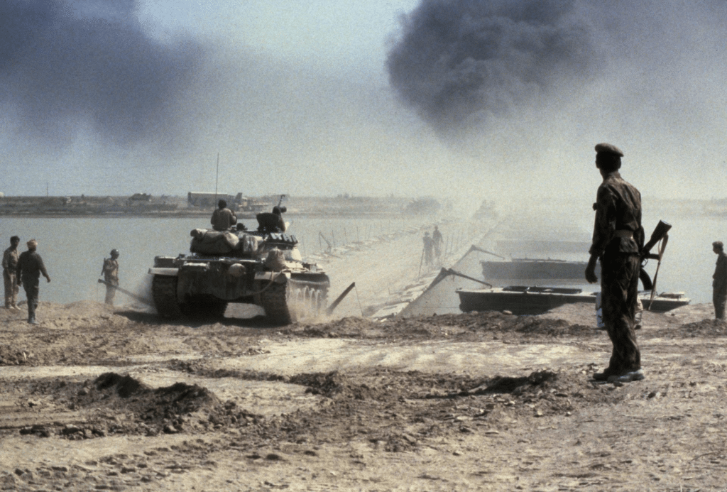 Carri armati e soldati iracheni attraversano un ponte di barche sul fiume Karun per raggiungere la zona a nord-est del porto petrolifero iraniano di Khorramshahr durante la guerra Iran-Iraq, ottobre 1980.