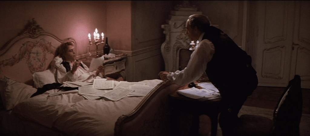 Un fermoimmagine tratto dalla celeberrima scena del film "Amadeus" con Mozart in fin di vita che ricontrolla la trascrizione di Salieri della dettatura del "Requiem".