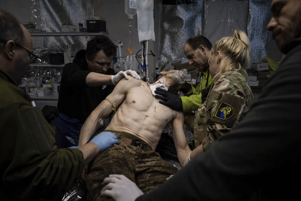 Medici militari ucraini curano un loro commilitone ferito durante la battaglia di Bakhmut.