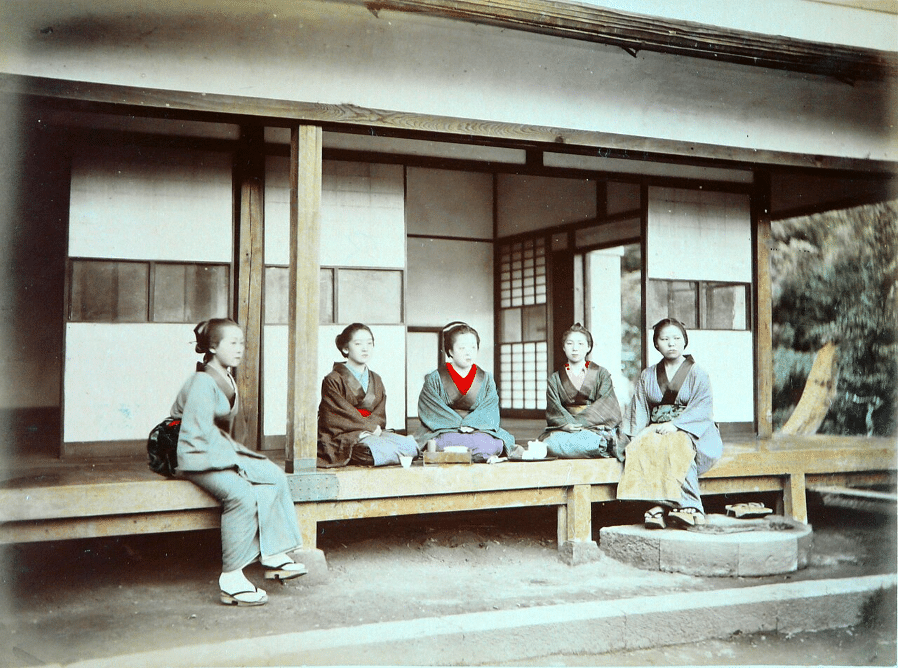 Fotografia storica che mostra alcune donne in kimono sull’engawa, la soglia aperta che unisce gli ambienti domestici al giardino.