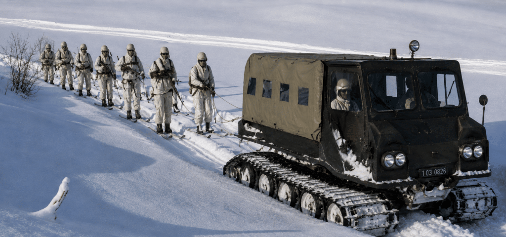 Truppe alpine su sci sono trainate dietro un veicolo da neve cingolato: l'Armee de Terre ha una divisione alpina, la 27eme DA, con base a Grenoble.