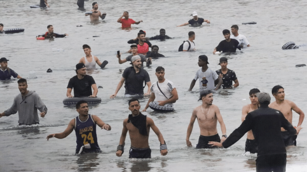 Membri delle forze dell'ordine spagnole sono scesi in acqua cercando di arginare il flusso di migranti marocchini giunti via mare.