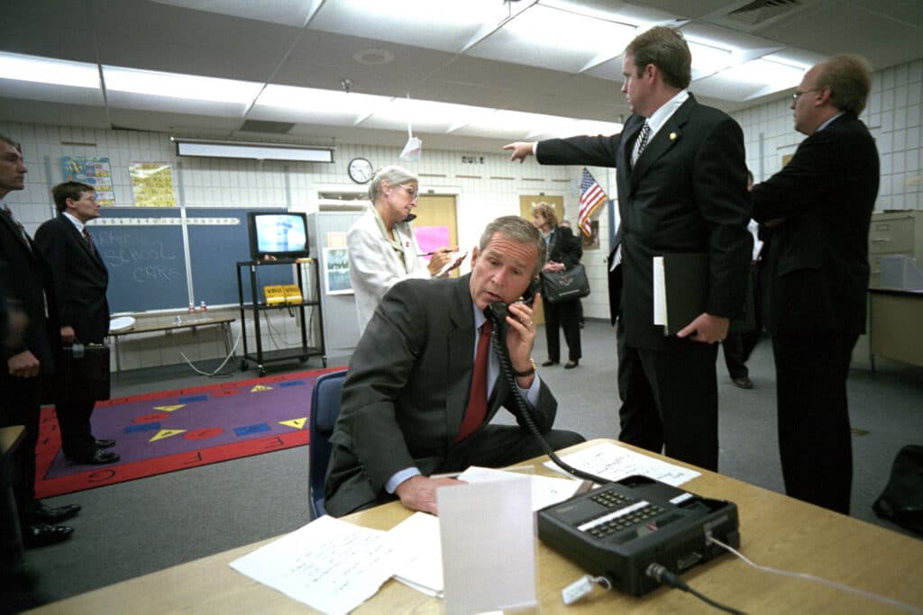George W. Bush al telefono mentre Dan Bartlett indica le immagini televisive del World Trade Center