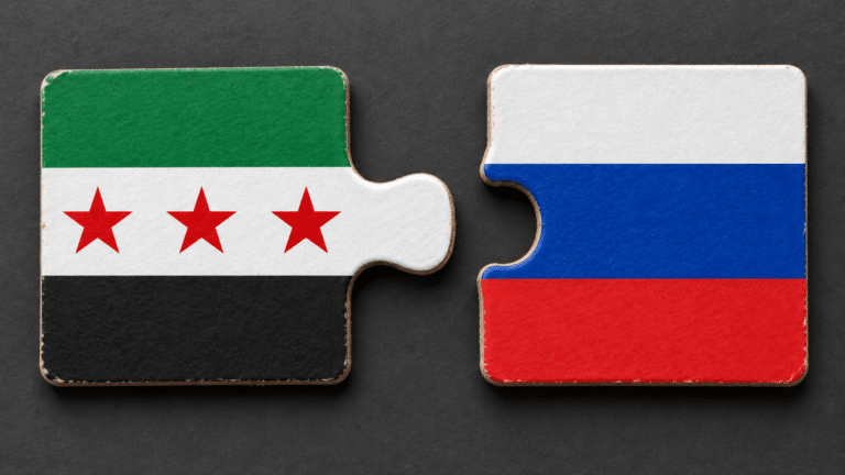 Bandiere di Siria e Russia su due tessere di puzzle, su sfondo grigio scuro
